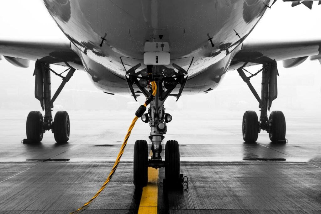 A high-angle view of a private jet parked on a tarmac, surrounded by various logistical items like fuel tanks, ground crew equipment, and luggage. The scene is bathed in warm, golden sunlight, creating a sense of activity and preparation for an upcoming flight. The foreground features stacks of paperwork, invoices, and a calculator, symbolizing the administrative and financial aspects of private jet charter. The middle ground showcases the jet's sleek exterior, while the background depicts a hazy, blurred horizon, suggesting the journey that lies ahead. The overall mood is one of efficiency, attention to detail, and the hidden costs associated with the luxury of private air travel. private jet parked on a tarmac, surrounded by various logistical items like fuel tanks, ground crew equipment, and luggage. The scene is bathed in warm, golden sunlight, creating a sense of activity and preparation for an upcoming flight. The foreground features stacks of paperwork, invoices, and a calculator, symbolizing the administrative and financial aspects of private jet charter. The middle ground showcases the jet's sleek exterior, while the background depicts a hazy, blurred horizon, suggesting the journey that lies ahead. The overall mood is one of efficiency, attention to detail, and the hidden costs associated with the luxury of private air travel.