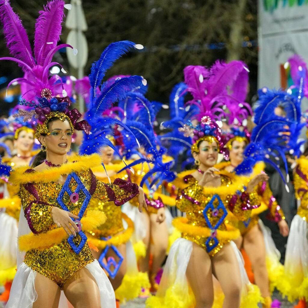 Vibrant carnival parade in a lush, tropical landscape. Colorful feathered headdresses and festive costumes against a backdrop of swaying palm trees. Misty peaks of the Andes in the distance, shrouded in a veil of rain. Warm, golden sunlight filters through the clouds, casting a glow over the joyous celebration. Crowds of people dancing and celebrating, their faces alight with excitement. The scene exudes a sense of warmth, energy and natural beauty that embodies the essence of South America in February. Vibrant carnival parade in a lush, tropical landscape. Colorful feathered headdresses and festive costumes against a backdrop of swaying palm trees. Misty peaks of the Andes in the distance, shrouded in a veil of rain. Warm, golden sunlight filters through the clouds, casting a glow over the joyous celebration. Crowds of people dancing and celebrating, their faces alight with excitement. The scene exudes a sense of warmth, energy and natural beauty that embodies the essence of South America in February.