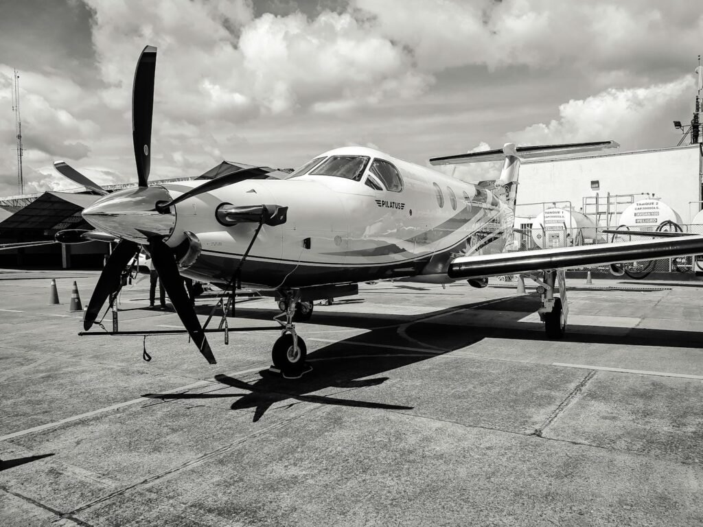 A meticulously detailed, ultra-realistic photo showcasing the comprehensive financial factors that contribute to the total cost of owning and operating a small private airplane. In the foreground, a breakdown of fixed costs like insurance, maintenance, and hangar fees, presented on a sleek, minimalist dashboard interface. In the middle ground, a detailed spreadsheet displaying variable costs such as fuel, oil, and pilot salaries, rendered with striking clarity. The background features a serene, sunlit tarmac, with the silhouette of a well-appointed private jet in the distance, symbolizing the high-end nature of aircraft ownership. Lighting is natural and directional, casting subtle shadows that enhance the sense of depth and realism. The overall composition conveys the complex financial realities that drive annual budgets for small plane owners. Black and white image of a modern aircraft at Bogotá airport under a cloudy sky, photo showcasing the comprehensive financial factors that contribute to the total cost of owning and operating a small private airplane. In the foreground, a breakdown of fixed costs like insurance, maintenance, and hangar fees, presented on a sleek, minimalist dashboard interface. In the middle ground, a detailed spreadsheet displaying variable costs such as fuel, oil, and pilot salaries, rendered with striking clarity. The background features a serene, sunlit tarmac, with the silhouette of a well-appointed private jet in the distance, symbolizing the high-end nature of aircraft ownership. Lighting is natural and directional, casting subtle shadows that enhance the sense of depth and realism. The overall composition conveys the complex financial realities that drive annual budgets for small plane owners.