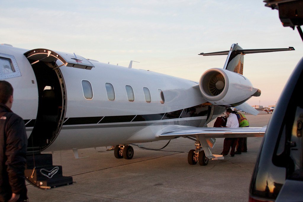 Ultra-realistic photo of a private jet on the tarmac, with various financial documents and charts floating above it, conveying the complex pricing factors beyond the hourly flight rate. In the foreground, a magnifying glass highlights the fine print of a contract, drawing attention to hidden fees and taxes. The middle ground features a calculator and a laptop, symbolizing the meticulous cost calculations required. In the background, a city skyline of Las Vegas can be seen, hinting at the destination. The scene is bathed in a warm, golden light, creating a sense of luxury and high-end travel. The overall composition emphasizes the need to consider the full financial picture when booking a private jet charter to Las Vegas. photo of a private jet on the tarmac, with various financial documents and charts floating above it, conveying the complex pricing factors beyond the hourly flight rate. In the foreground, a magnifying glass highlights the fine print of a contract, drawing attention to hidden fees and taxes. The middle ground features a calculator and a laptop, symbolizing the meticulous cost calculations required. In the background, a city skyline of Las Vegas can be seen, hinting at the destination. The scene is bathed in a warm, golden light, creating a sense of luxury and high-end travel. The overall composition emphasizes the need to consider the full financial picture when booking a private jet charter to Las Vegas.
