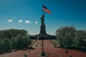 a flag on a flagpole with statue of liberty in day trips in ny