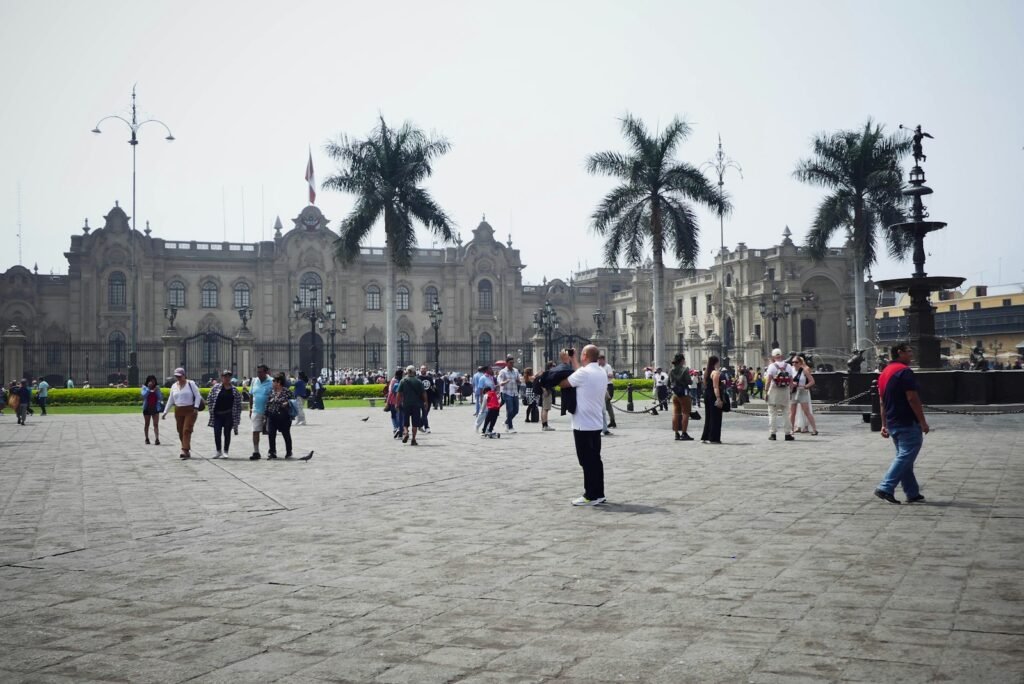 A panoramic view of the South American continent in 2025, showcasing its diverse landscapes and vibrant cities. In the foreground, a group of travelers exploring a lush, tropical setting, seemingly carefree and immersed in the local culture. The middle ground features bustling metropolitan areas, with modern skyscrapers and infrastructure, signifying economic growth and stability. In the background, a tapestry of mountain ranges, pristine beaches, and winding rivers, capturing the region's natural beauty. The lighting is warm and inviting, casting a golden glow over the scene, conveying a sense of safety and security. The overall atmosphere exudes a welcoming and adventurous spirit, enticing viewers to consider South America as a top travel destination for 2025. A panoramic view of the South American continent, showcasing its diverse landscapes and vibrant cities. In the foreground, a group of travelers exploring a lush, tropical setting, seemingly carefree and immersed in the local culture. The middle ground features bustling metropolitan areas, with modern skyscrapers and infrastructure, signifying economic growth and stability. In the background, a tapestry of mountain ranges, pristine beaches, and winding rivers, capturing the region's natural beauty. The lighting is warm and inviting, casting a golden glow over the scene, conveying a sense of safety and security. The overall atmosphere exudes a welcoming and adventurous spirit, enticing viewers to consider South America as a top travel destination, a group of people walking around a large building