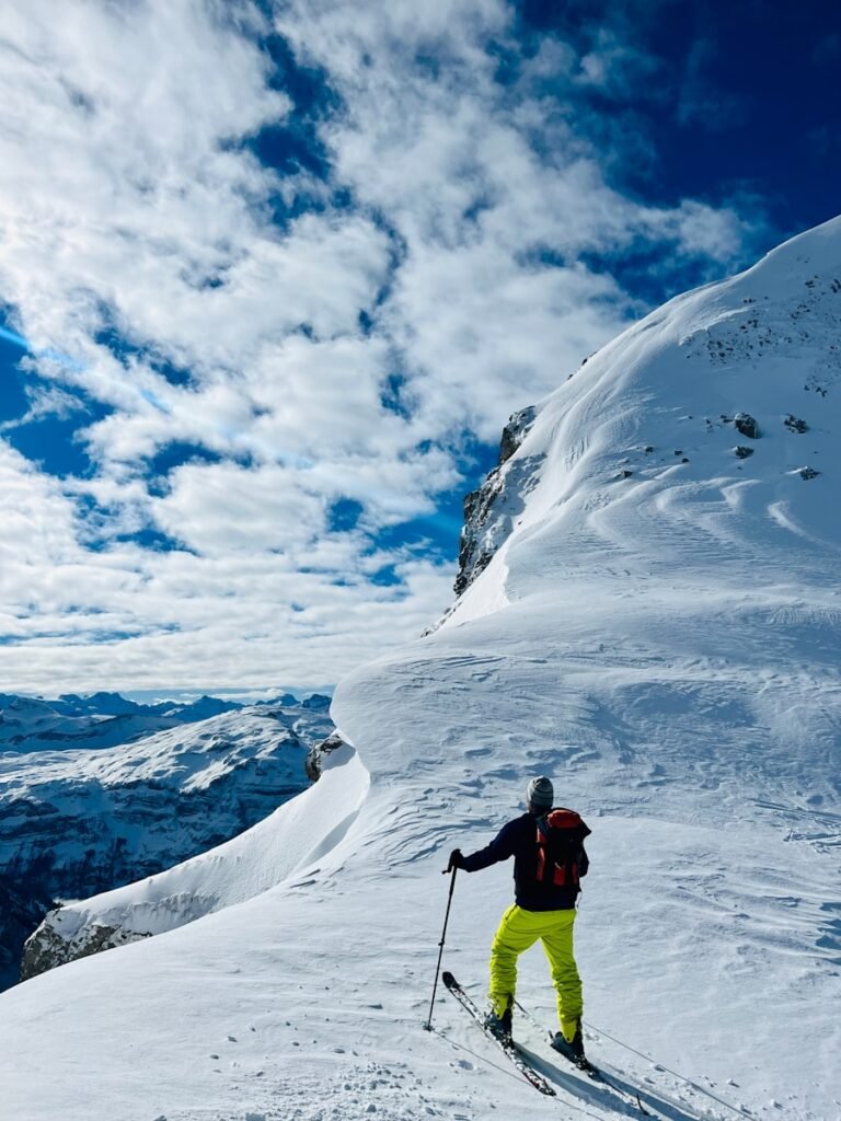 An ultra-realistic photo of South America in August, showcasing the region's diverse highlights during this time of year. In the foreground, snow-capped Andean peaks rise majestically, their slopes dotted with skiers carving graceful turns. In the middle ground, the dry, arid highlands of the Altiplano stretch out, their ochre hues contrasting with the deep azure sky. In the background, lush tropical forests thrive, with fewer rainfalls in the northern parts of the continent. The lighting is warm and golden, capturing the essence of the season's best travel experiences across South America. photo of South America in August, showcasing the region's diverse highlights during this time of year. In the foreground, snow-capped Andean peaks rise majestically, their slopes dotted with skiers carving graceful turns. In the middle ground, the dry, arid highlands of the Altiplano stretch out, their ochre hues contrasting with the deep azure sky. In the background, lush tropical forests thrive, with fewer rainfalls in the northern parts of the continent. The lighting is warm and golden, capturing the essence of the season's best travel experiences across South America, a man riding skis down the side of a snow covered slope