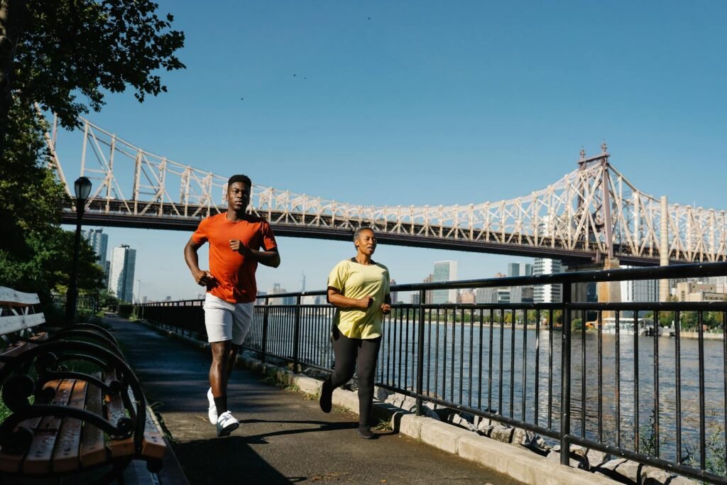 A bustling waterfront cityscape, with iconic bridges spanning the shimmering river. In the foreground, a lively promenade teeming with pedestrians, joggers, and cyclists enjoying the scenic route. Towering skyscrapers and historic buildings form the dynamic skyline, bathed in warm, golden sunlight. The scene exudes an atmosphere of vibrant energy and outdoor adventure, perfect for families seeking an engaging, walkable experience. Shot with a wide-angle lens to capture the grandeur of the urban landscape, this ultra-realistic photo immerses the viewer in the excitement of a thriving metropolis.