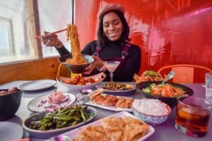 Best food in NYC ,a woman savoring a delightful Asian cuisine meal at a New York City restaurant.