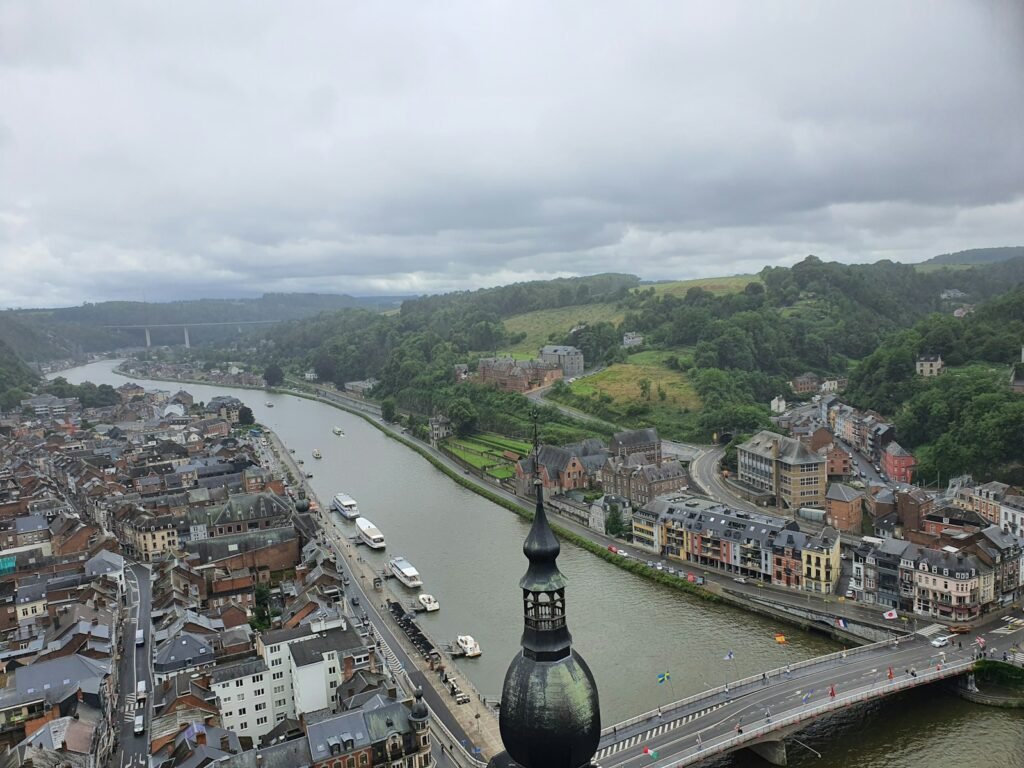 A sweeping landscape stretching from the majestic Rhine River to the snow-capped peaks of the Alps. In the foreground, rolling hills blanketed in lush green forests, with a winding road leading past quaint towns and villages. The middle ground reveals the grand cathedrals and castles of Germany, Belgium, and Luxembourg, their timeless silhouettes reflected in shimmering lakes. In the distance, the mighty Austrian Alps rise, their jagged summits piercing the azure sky, bathed in golden afternoon light. A sense of timeless grandeur and historical resonance permeates the scene, inviting the viewer to embark on an unforgettable journey through the heart of Europe.
