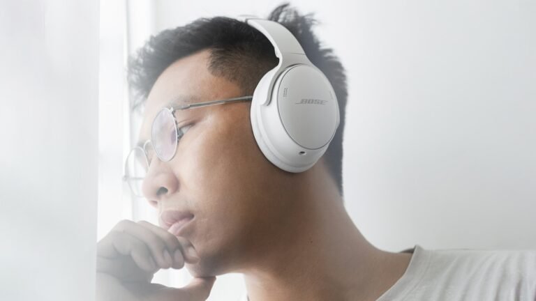 A man wearing a white headphone in a airplane, which is one of the best noise canceling headphones for Flights.