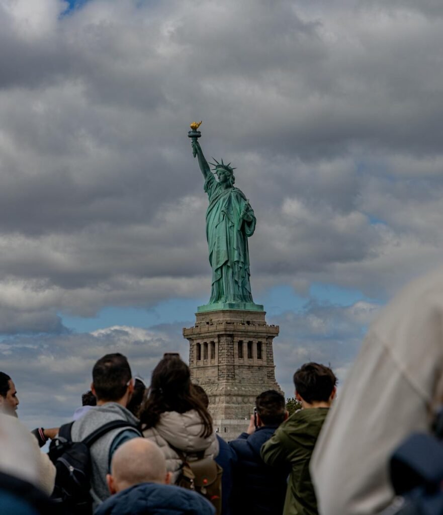 Crowd of visitors around the Statue of Liberty, one of the most popular free things to do in NYC.