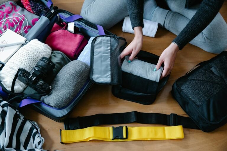 a woman packing clothes in packing cubes for traveling and wondering are packing cubes worth it.