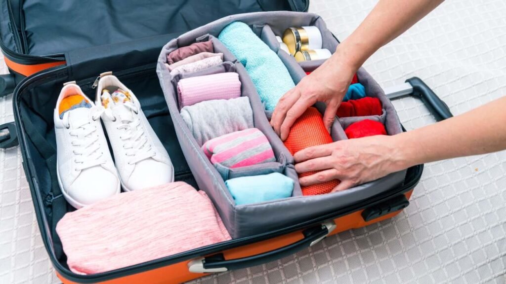 Traveler using packing cubes to neatly organize clothes and maximize luggage space in a suitcase.