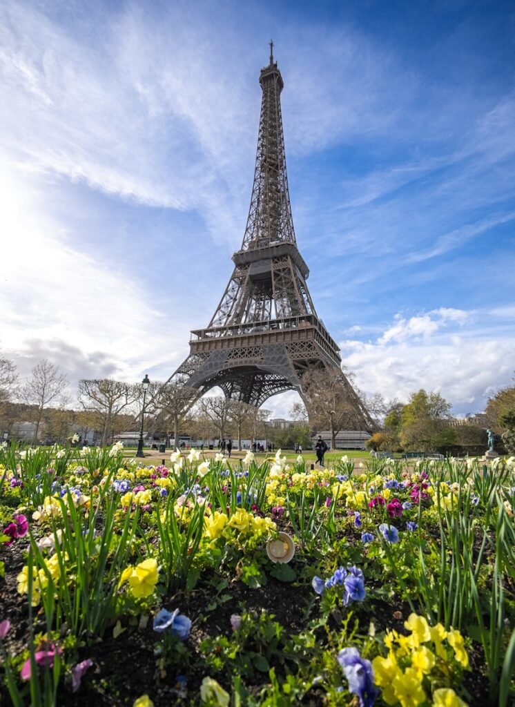 Exploring Europe: A Complete Guide to the Best Travel Experiences Eiffel Tower in spring surrounded by colorful flowers, symbolizing the best time for exploring Europe’s outdoor adventures and festivals.