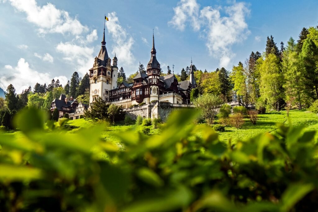 Exploring Europe: A Complete Guide to the Best Travel Experiences Peleș Castle in Sinaia, Romania, surrounded by green hills — a must-see landmark for travelers exploring Europe’s elegant historic sites.