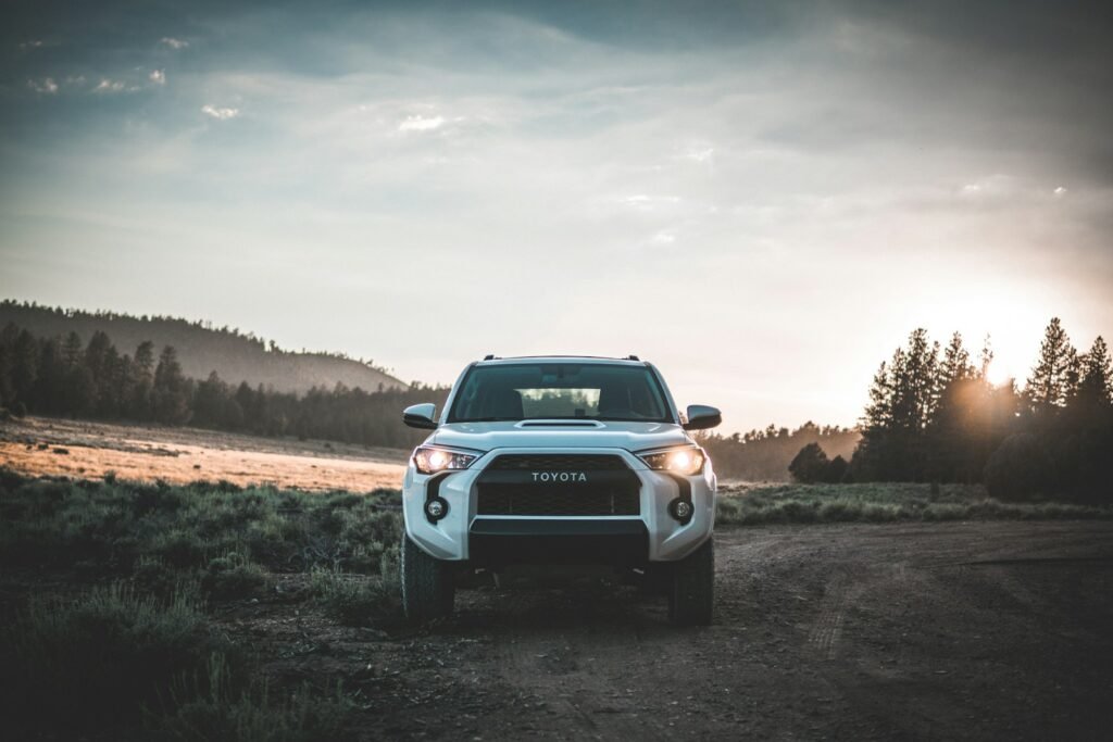White SUV parked on a dirt road at sunrise, representing flexible options for a london car for rent.